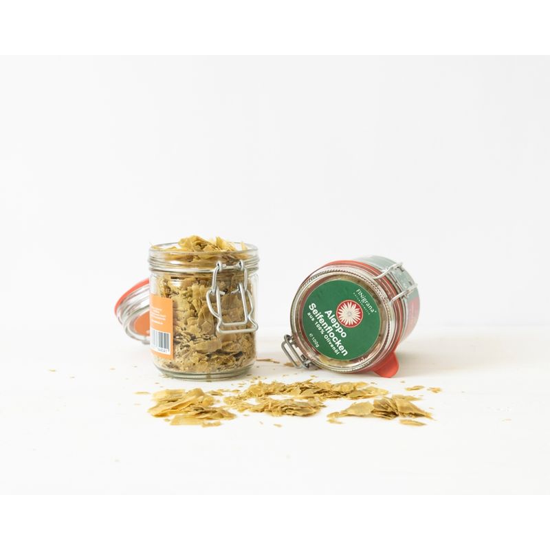 FINigrana® Naturkosmetik FINigrana Aleppo Seifenflocken, reine Olive, 100g im praktischen Glas mit Info, zur milden Haut, Haar und Körper Reinigung & Pflege aller Hauttypen, für Voll- & Teil Bäder, sowie als universelles Wasch- & Reinigungsmittel im ganzen Haushalt einsetzbar - Produktbild